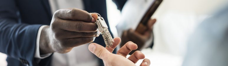 Real estate agent handing the house key to a client